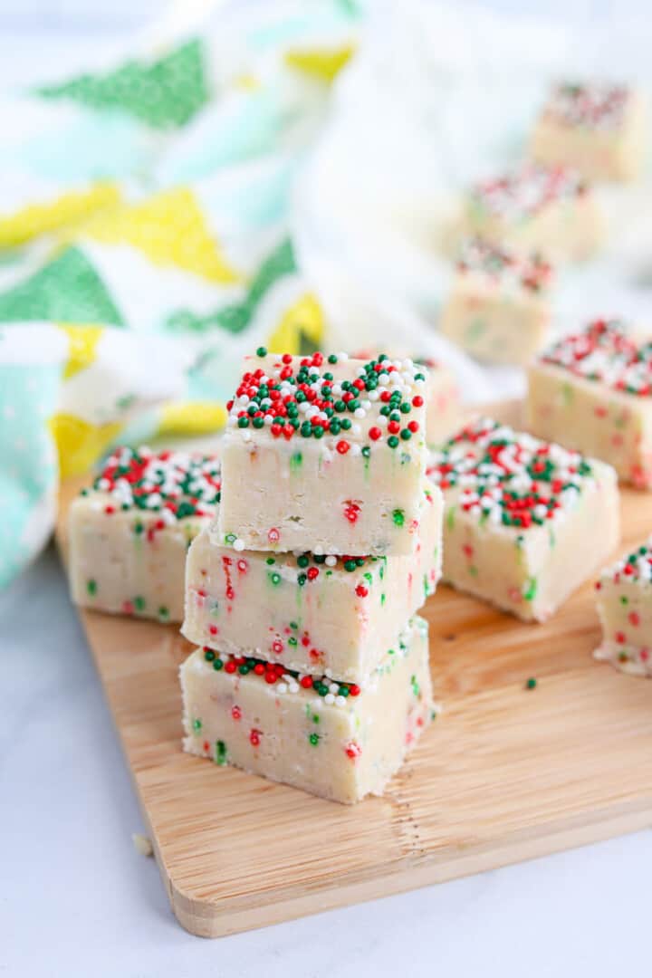 Christmas Cookie Fudge stacked on wooden board.