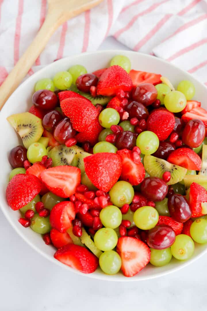 fruit salad mixed up in white bowl.