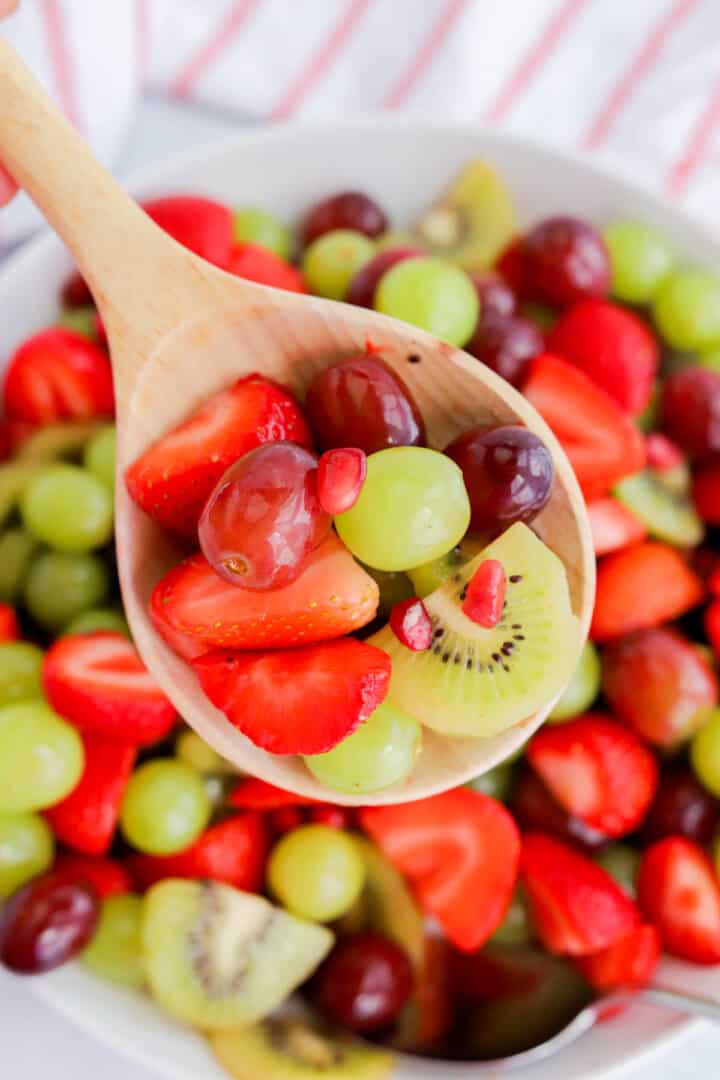 Christmas Fruit Salad on a wooden spoon.