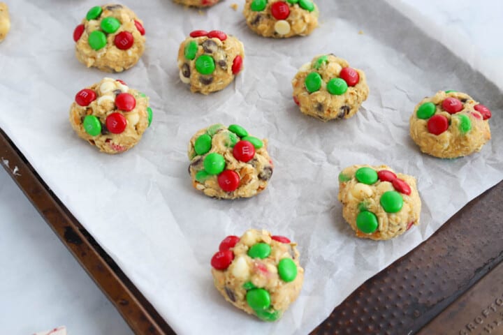 cookie dough balls on baking sheet with parchment paper.