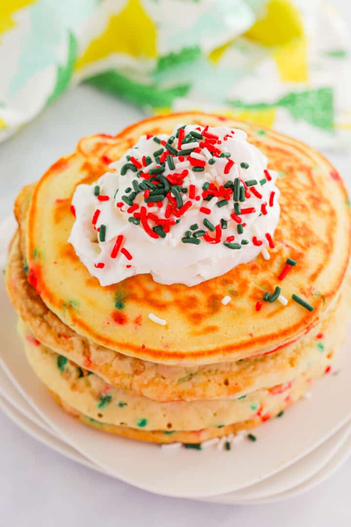 Christmas pancakes stacked on white plates.