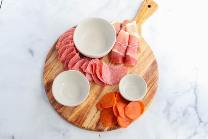 arranging the meats on the board.