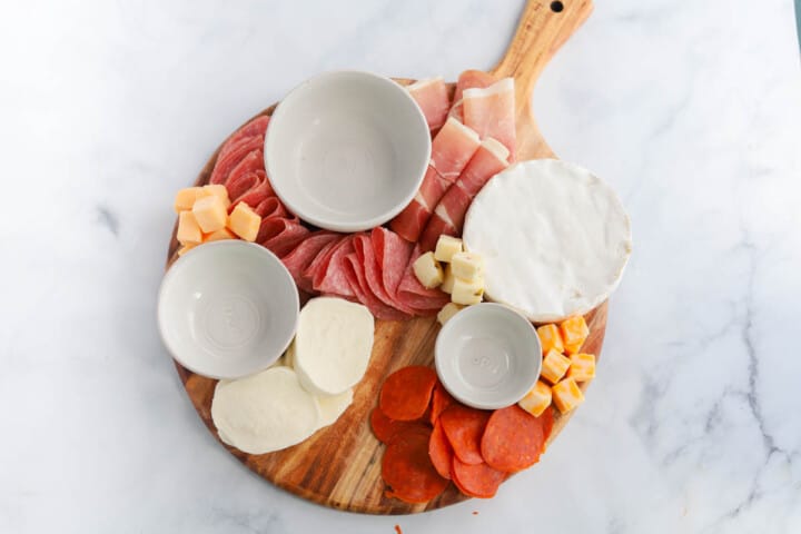 adding the cubed hard cheese to the board.