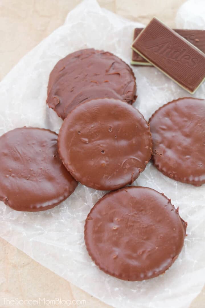 Homemade Thin Mints with Ritz Crackers stacked on parchment paper.