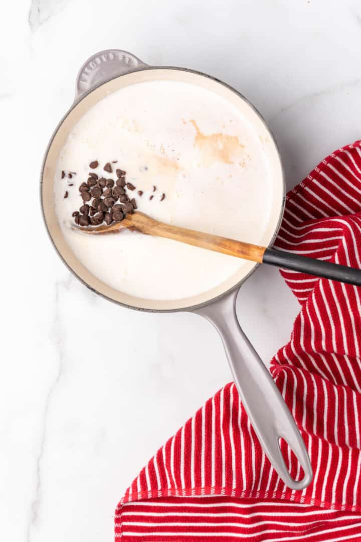 adding the chocolate chips to the hot chocolate.