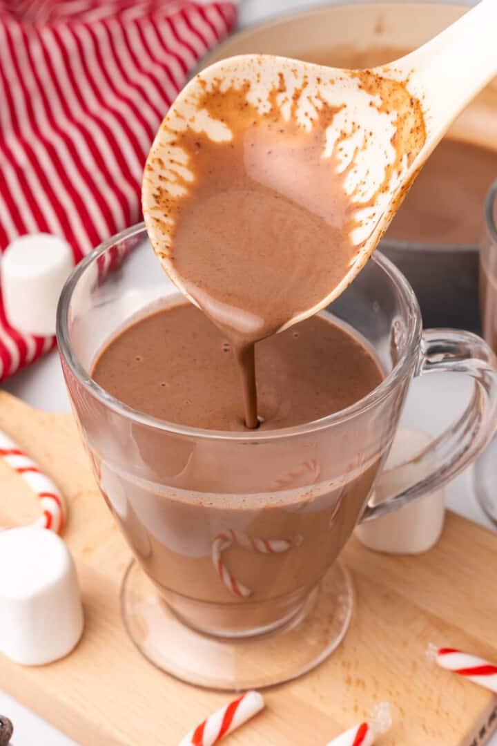 pouring the hot chocolate into a mug.