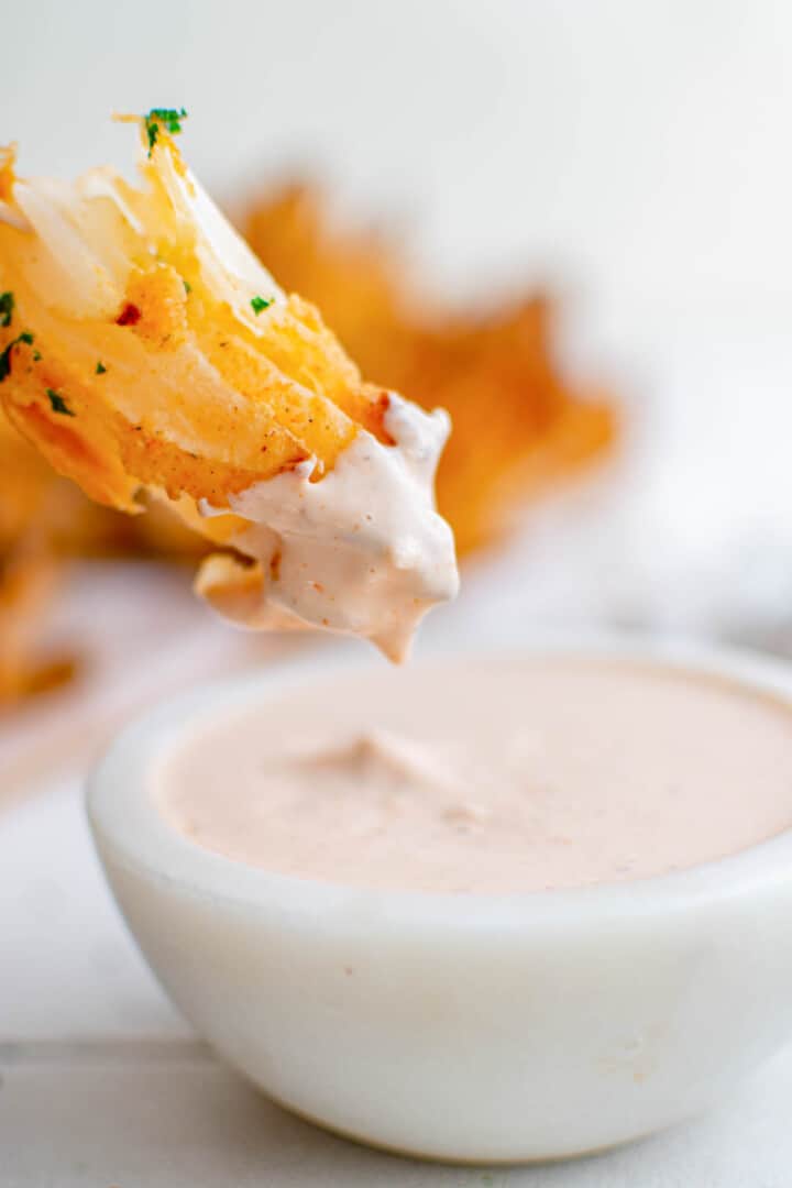 dipping blooming onion in horseradish dip.