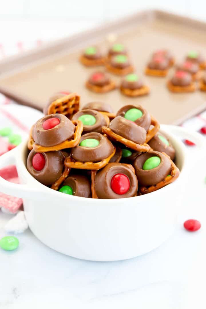 Rolo Pretzels in white serving bowl with baking sheet in the background.