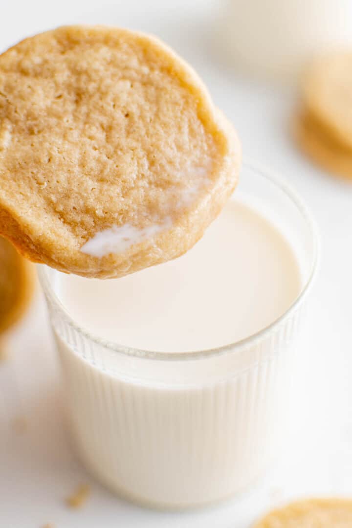 dipping a cookie in a glass of milk.