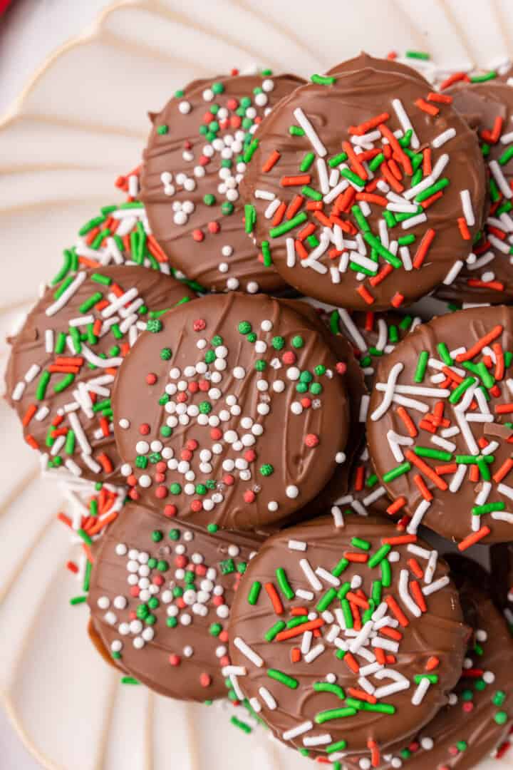 Chocolate Covered Oreos stacked on a white plate.