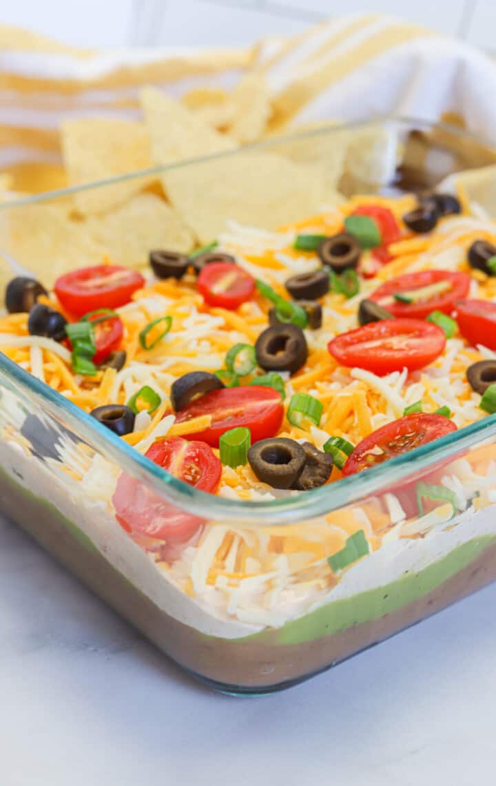 5 Layer Dip in glass dish with tortilla chips.
