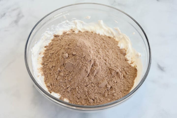 adding brownie mix to the cream cheese mix.