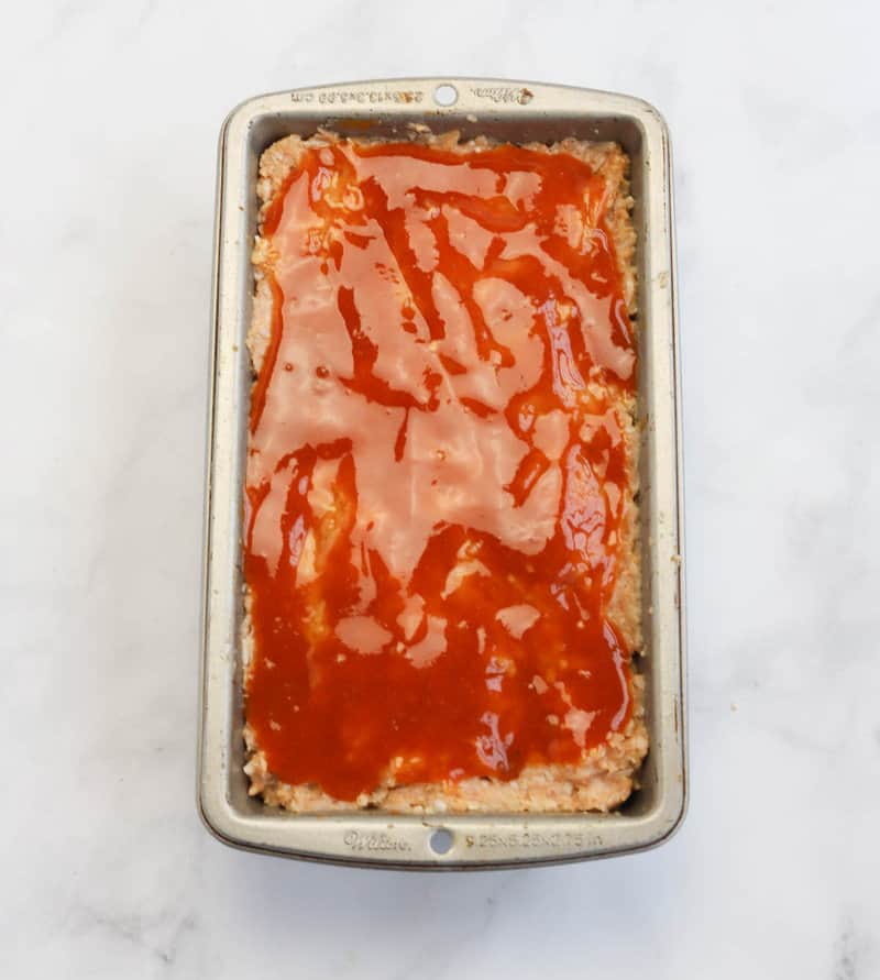 meatloaf in a pan topped with glaze.