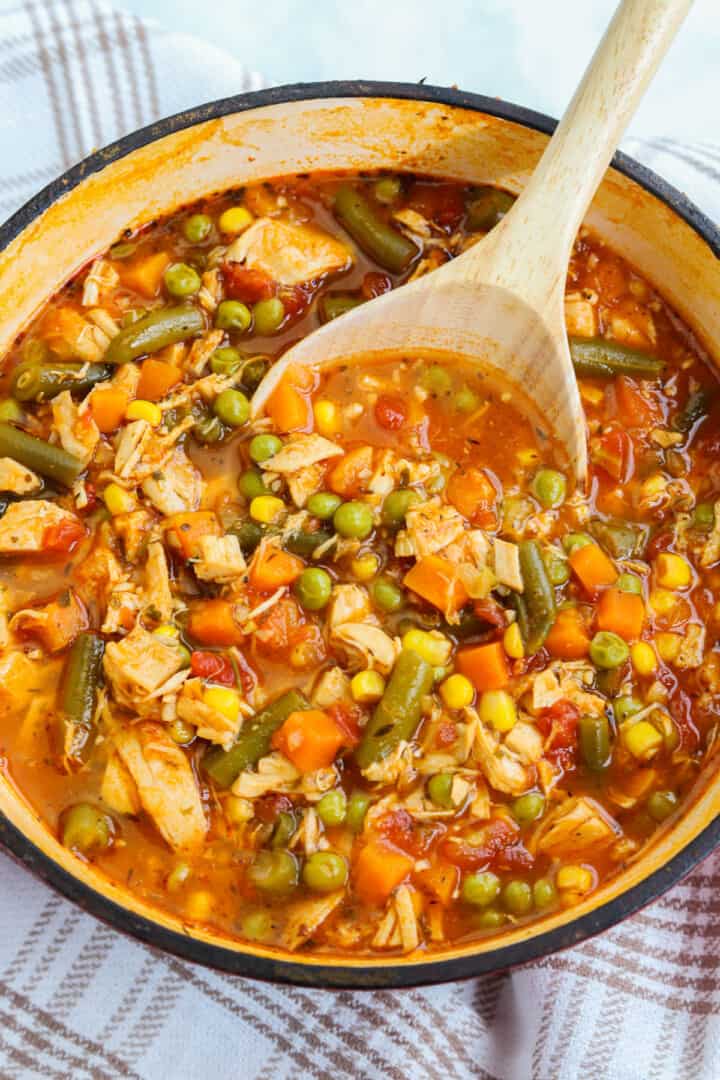 serving the soup with a wooden ladle.