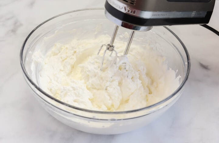 mixing the cream cheese and whipped cream together.