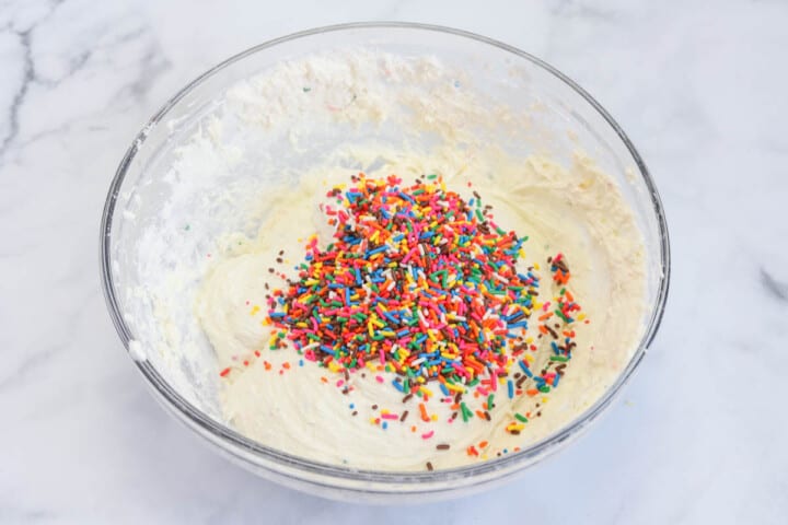 adding the sprinkles to the Funfetti dip.