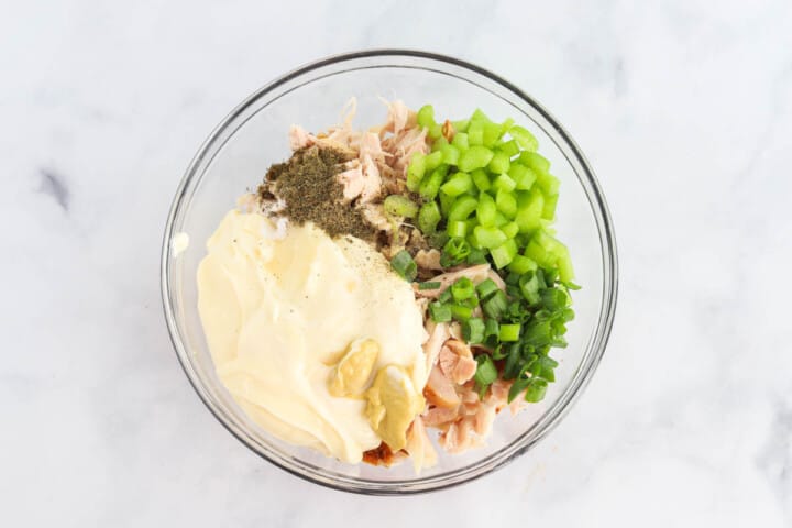 adding all ingredients for the chicken salad in a large bowl.