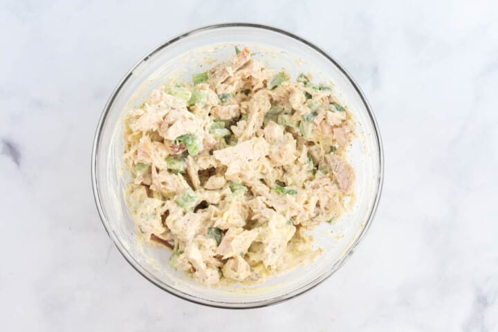 chicken salad mixed together in glass bowl.