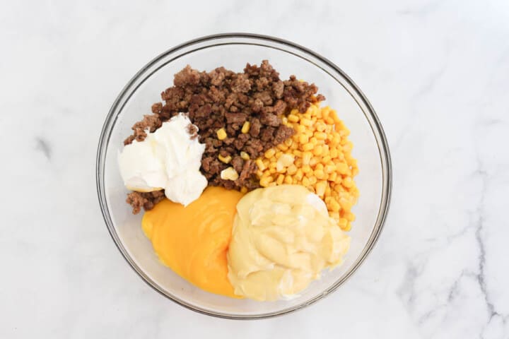 ingredients for tater tot casserole in large glass bowl.