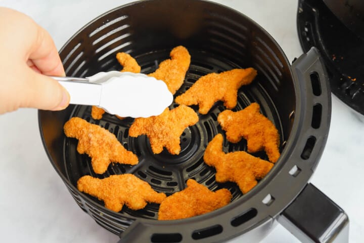 taking out the Dino Nuggets with tongs.