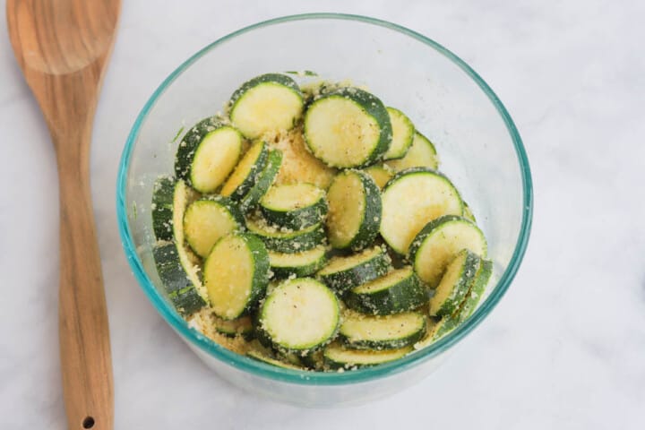 mixing the seasoning on the zucchini.