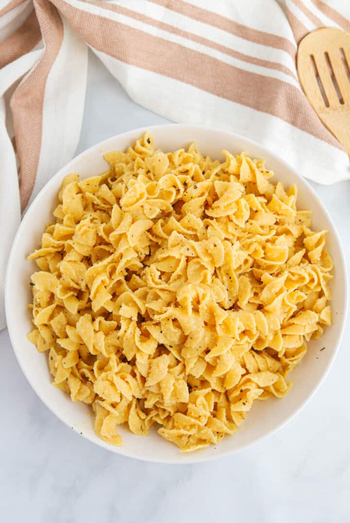 top view of buttered noodles in large white bowl.