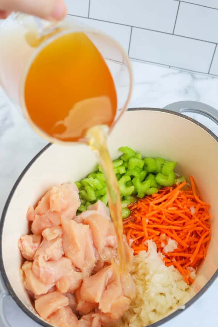 adding the chicken broth to the stock pot.