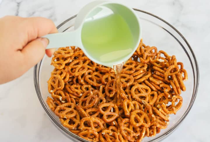 adding the oil to the pretzels for the seasoning.