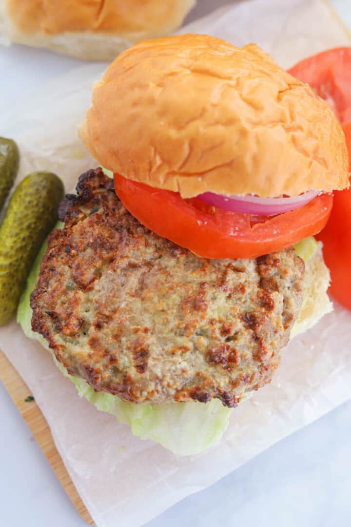 building the turkey burger on a wooden serving board.