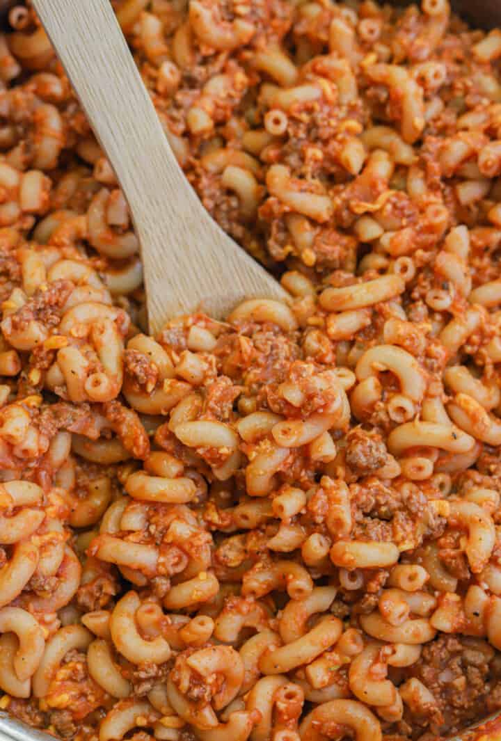 beefaroni all mixed up with wooden spoon.