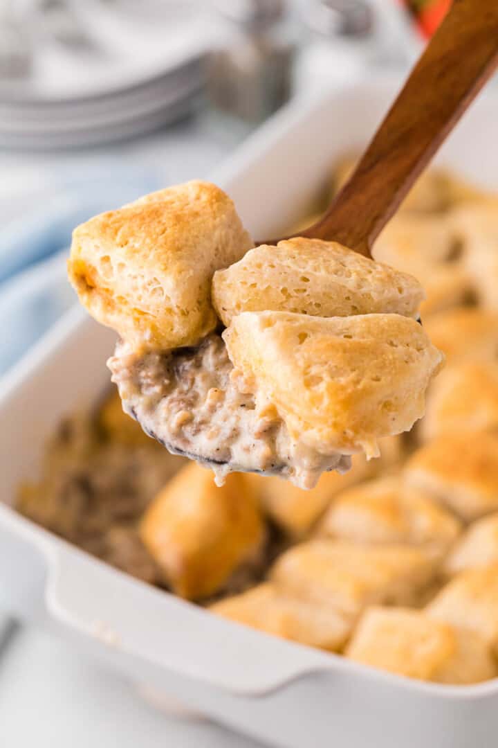 serving the casserole with a wooden spoon.