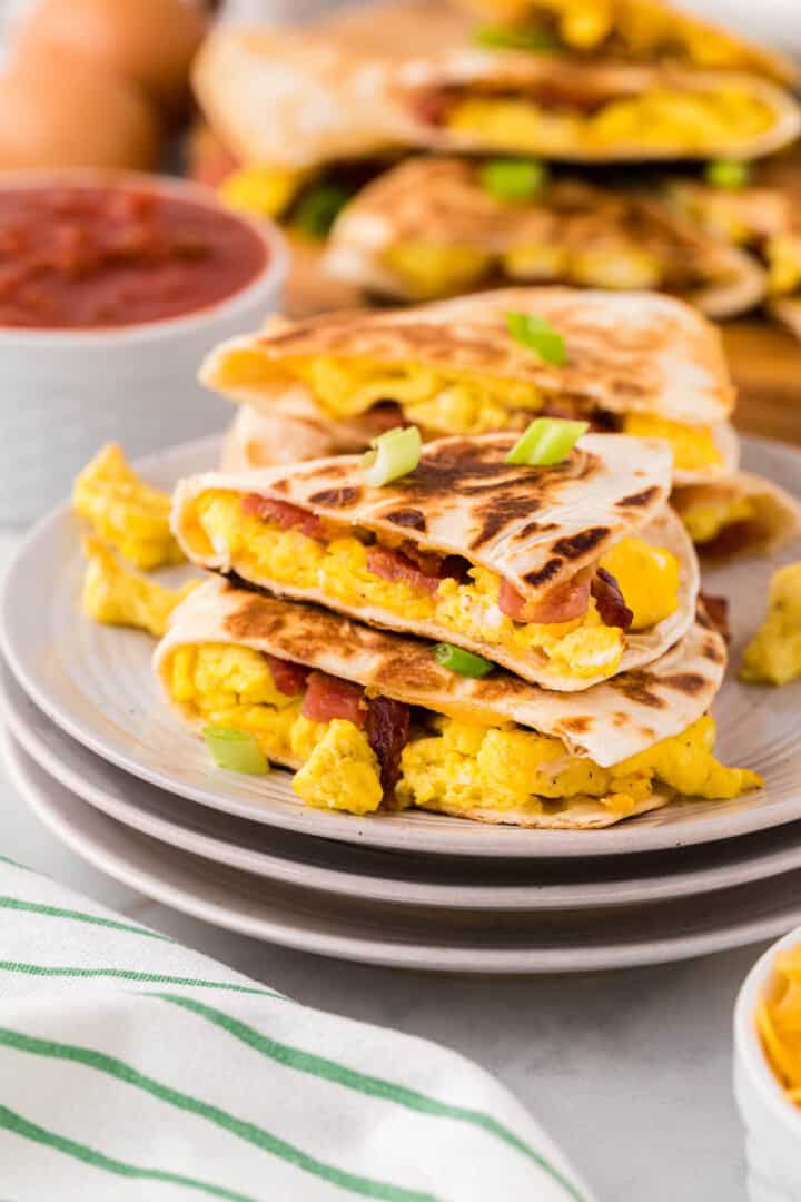 breakfast quesadillas sliced on stacked plates.