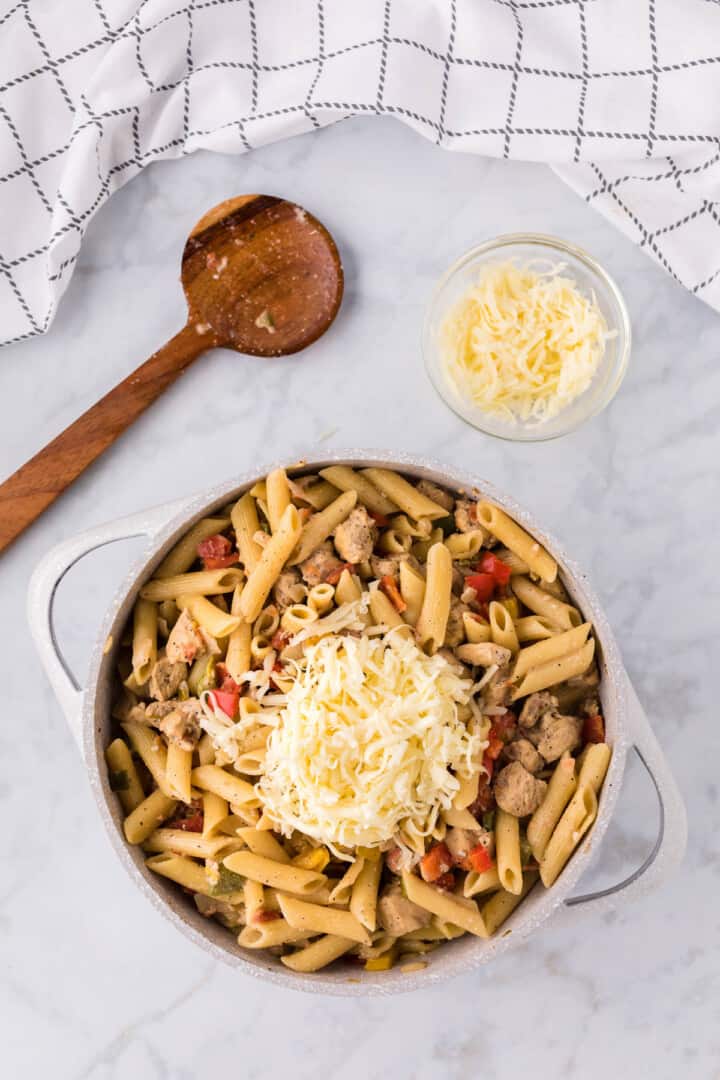 topping the pasta with cheese.