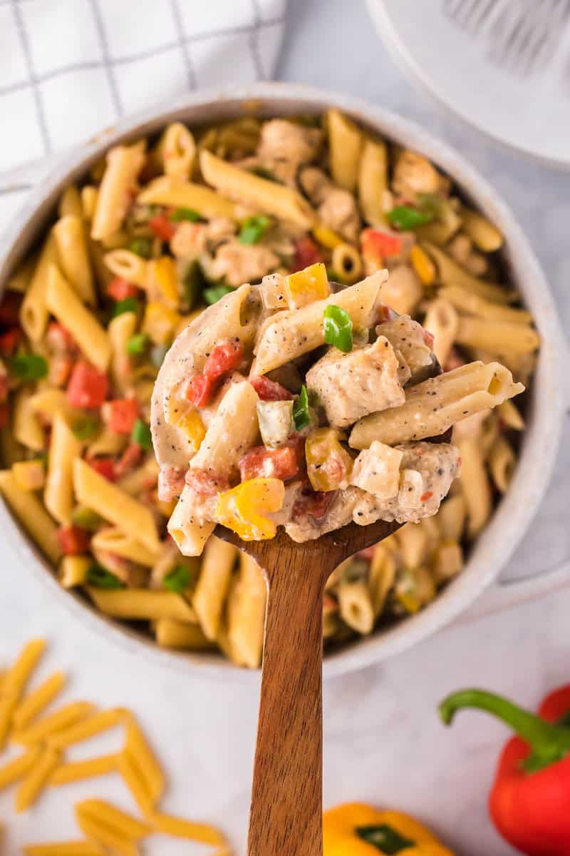 scooping out the chicken fajita pasta with wooden spoon.