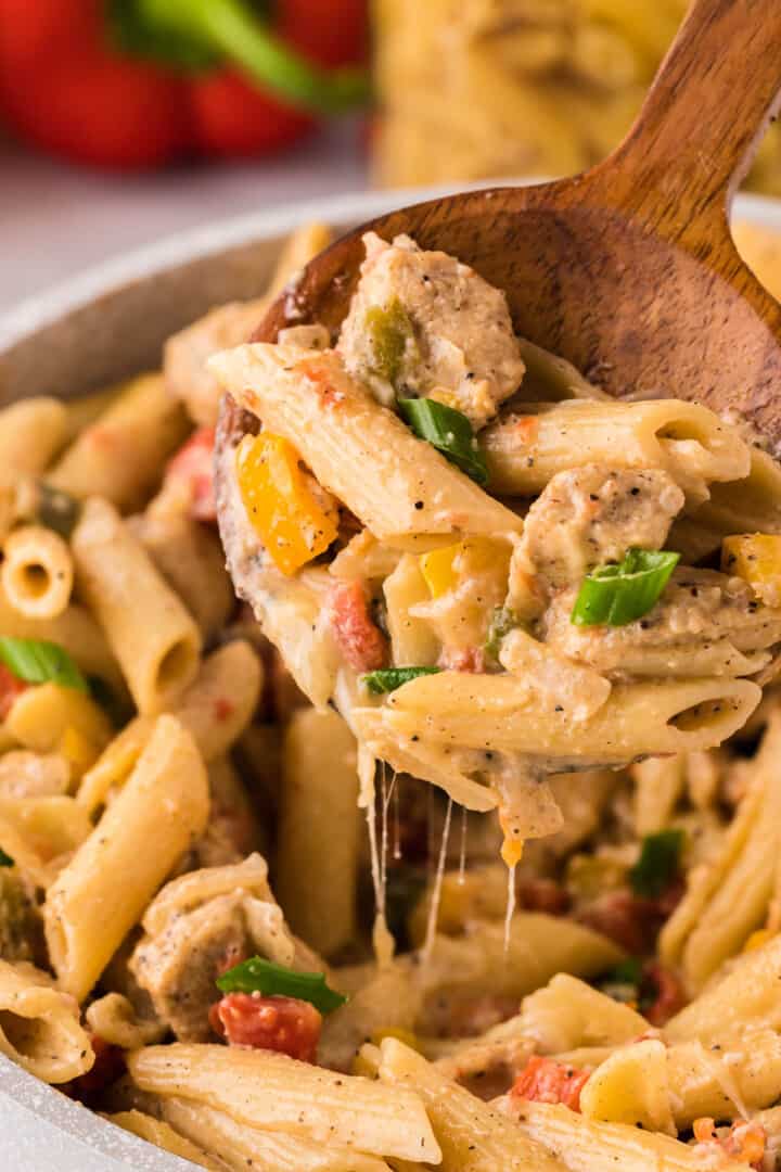 Chicken Fajita Pasta in large bowl being served with wooden spoon.