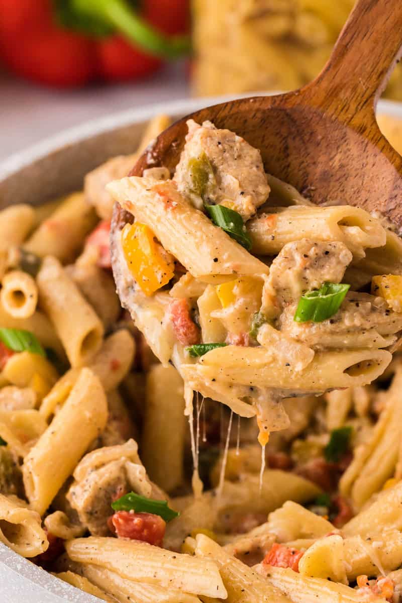 Chicken Fajita Pasta in large bowl being served with wooden spoon.