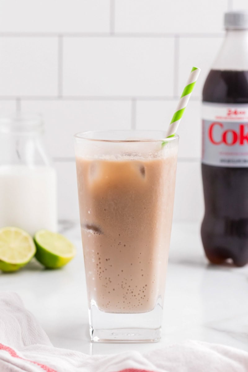 Dirty Soda Recipe with Diet Coke bottle and sliced limes.