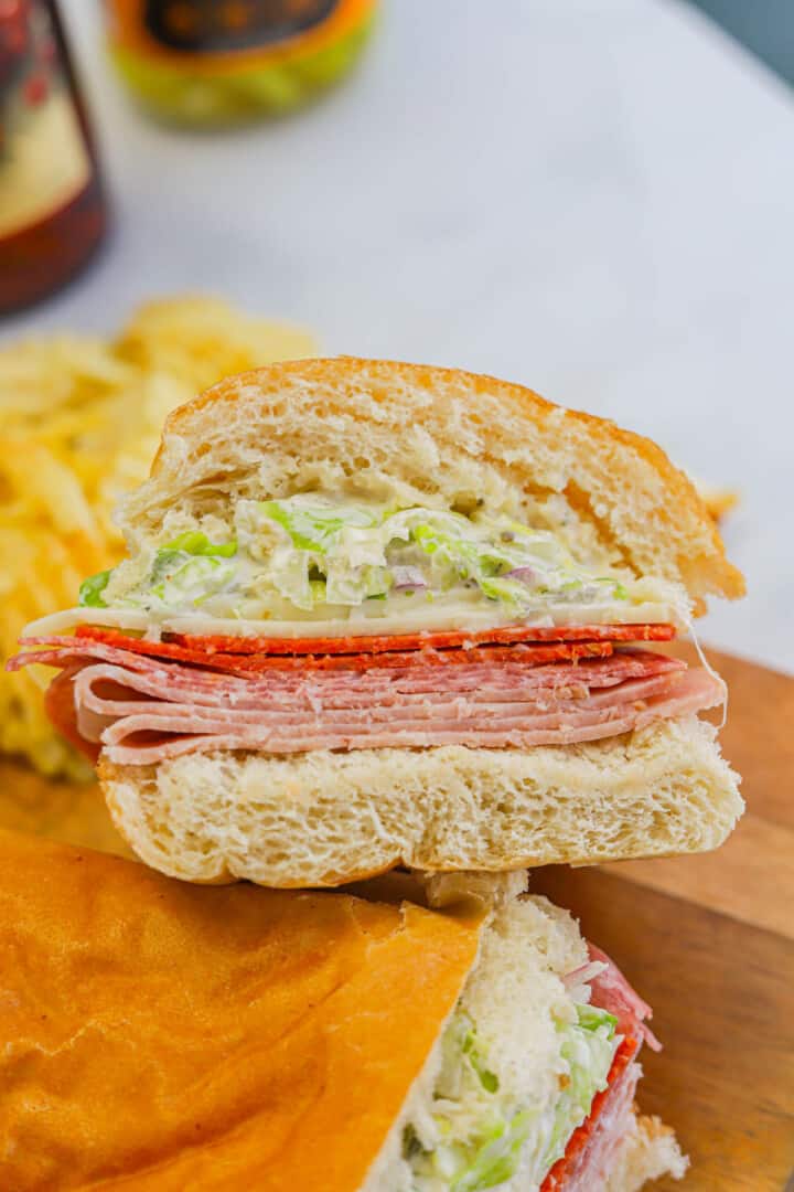 Grinder Sandwich on wooden serving board with chips.