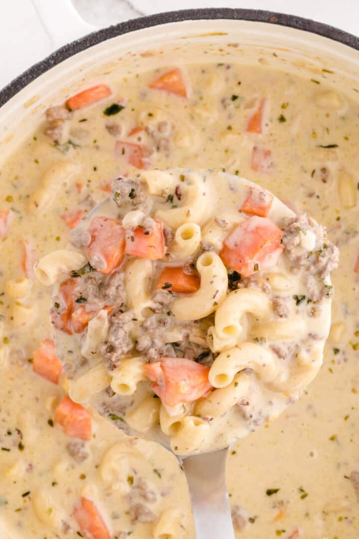 closeup of cheeseburger soup served with ladle.