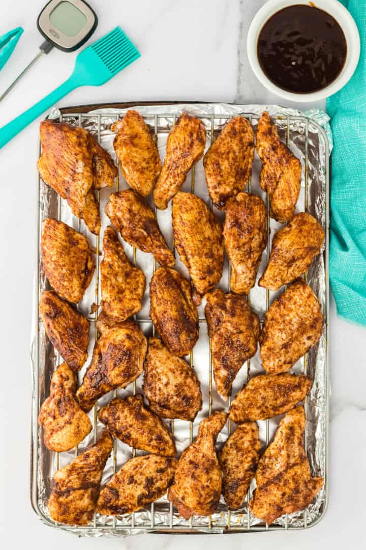 chicken wings with rub on the baking tray.