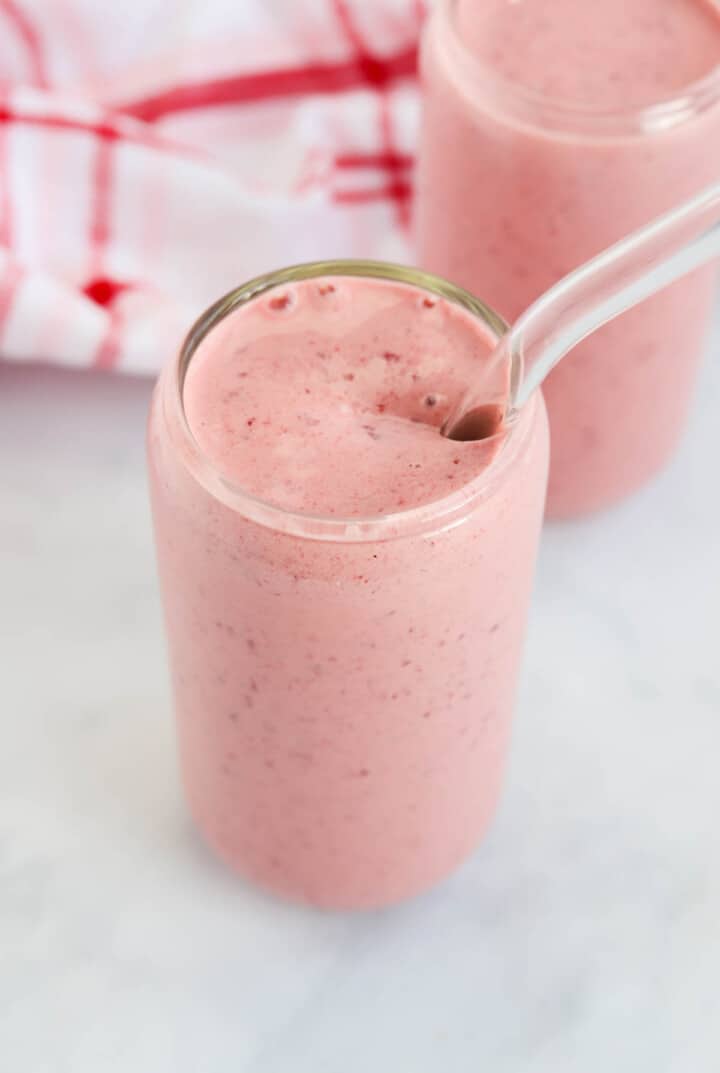 Cherry Smoothie in glass with glass straw.