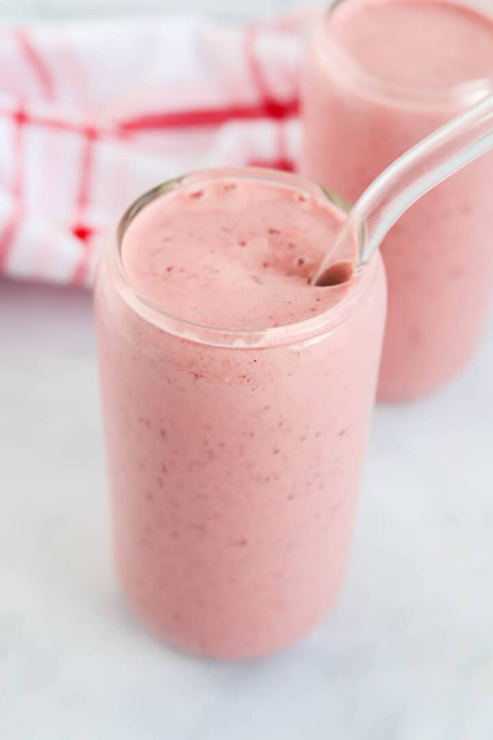 Cherry Smoothie in glass with glass straw.