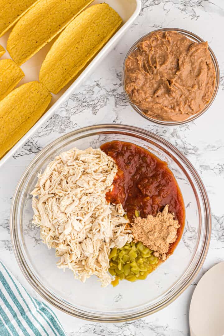 mixing together the chicken and ingredients for the tacos.