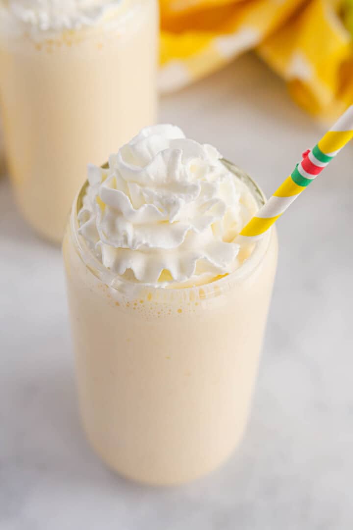closeup of Banana Milkshake topped with whipped cream.
