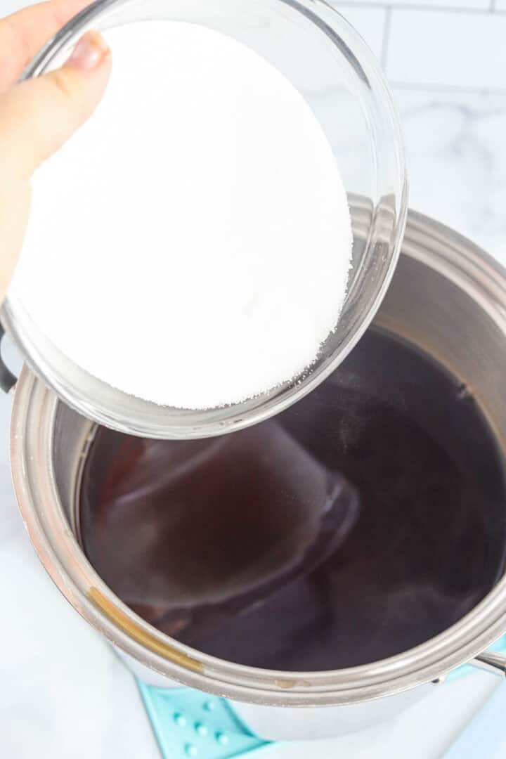 adding sugar to the brewed tea.