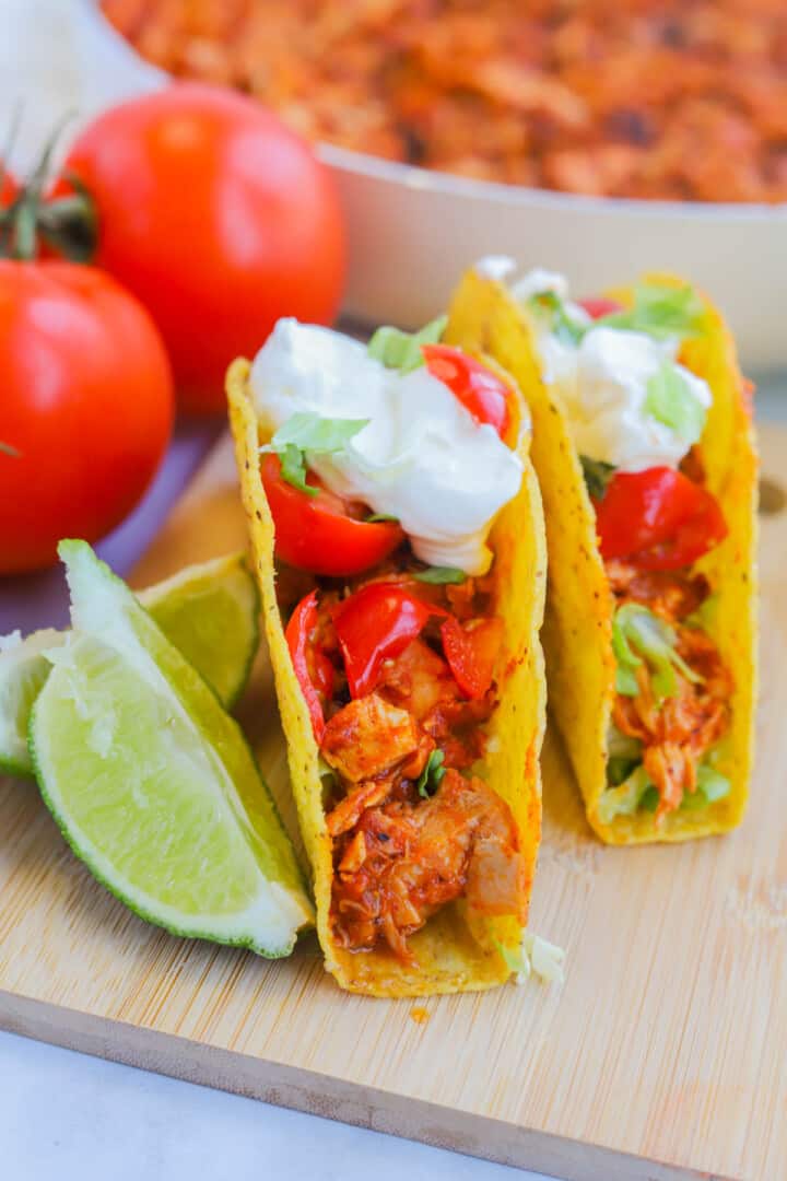 closeup of rotisserie chicken tacos on wooden board.