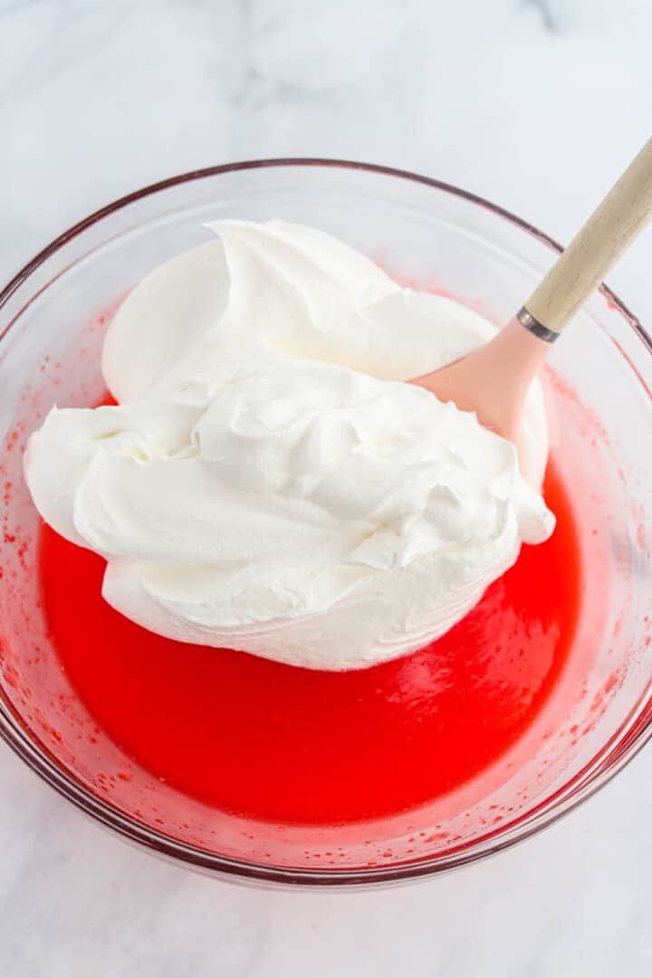 adding the whipped topping to the Jell-O.