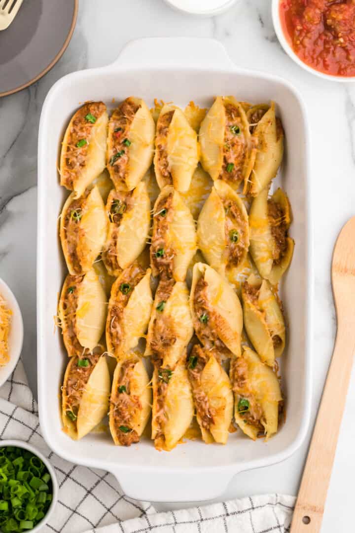 baked taco stuffed shells in casserole dish.