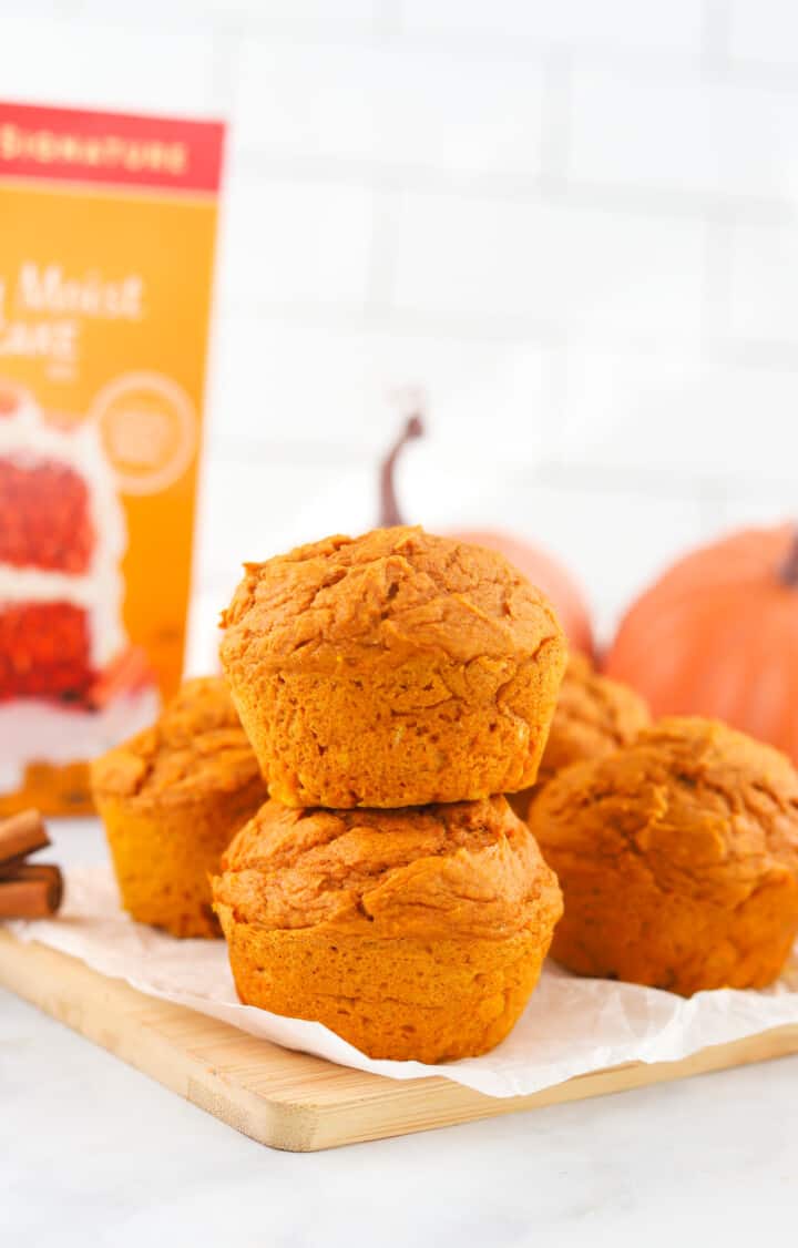 2 Ingredient Pumpkin Spice Muffins stacked on wooden serving board.