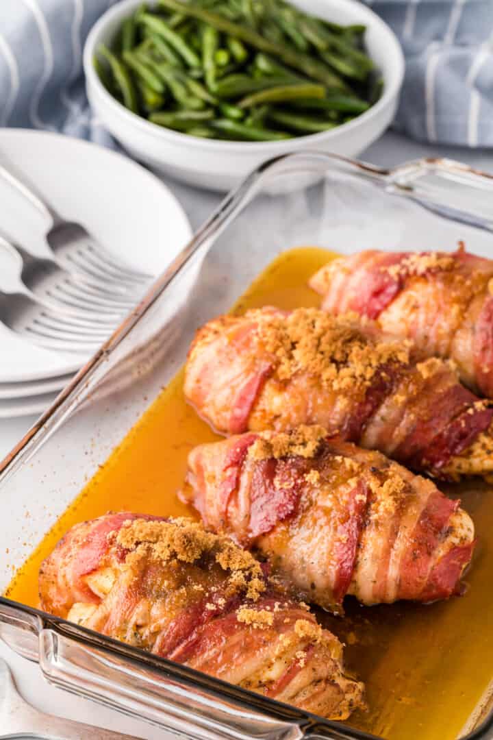 baked bacon wrapped chicken in baking dish.